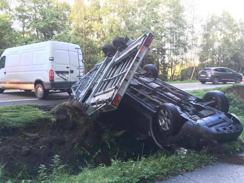Aanhangwagen met auto over de kop