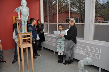 Kinderen lezen verhaaltje voor bij kunstwerk