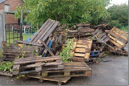 Lading afvalhout op binnenkoer gedumpt