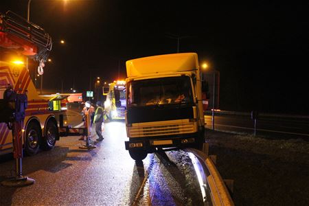 Vrachtwagen belandt boven op vangrails